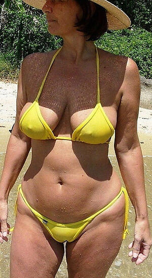 older woman in bikini poses naked